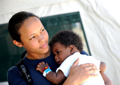Defense.gov News Photo 110819-N-NY820-351 - U.S. Navy Hospitalman Cherie Williams holds a patient at the Terminal Varroux medical site in Port-au-Prince Haiti on Aug. 19 2011 during
