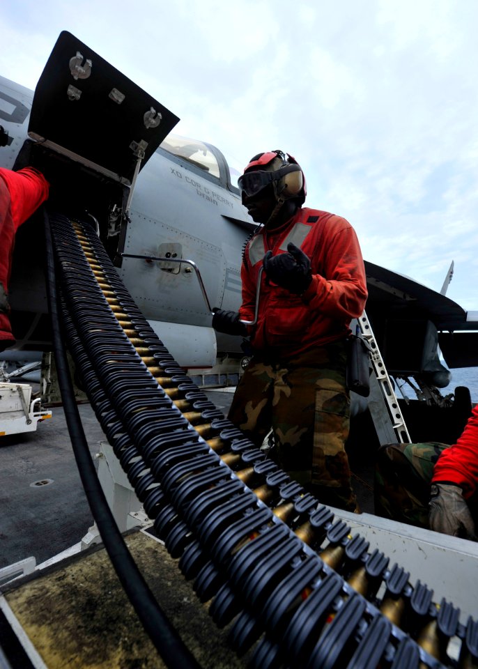 Defense.gov News Photo 110811-N-DS193-009 - Petty Officer 3rd Class Christian Jones uses a speed wrench to load 20mm high explosive incendiary rounds into an F A-18E Super Hornet assigned to