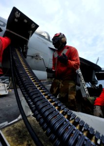 Defense.gov News Photo 110811-N-DS193-009 - Petty Officer 3rd Class Christian Jones uses a speed wrench to load 20mm high explosive incendiary rounds into an F A-18E Super Hornet assigned to