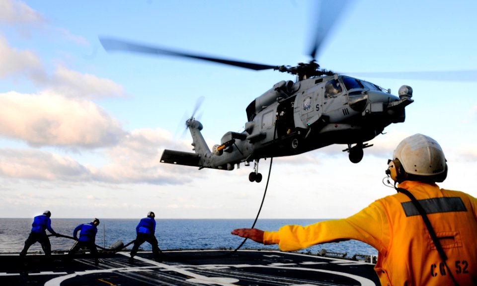Defense.gov News Photo 110910-N-BC134-200 - Petty Officer 2nd Class Alexander Black signals the pilot of an MH-60 Sea Hawk during an in-flight refueling from the guided-missile cruiser USS