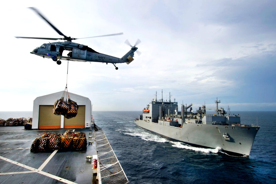 Defense.gov News Photo 110726-N-RM525-342 - An MH-60S Knight Hawk helicopter transports cargo from the USNS Comfort to the USNS Lewis and Clark during a replenishment mission underway in the
