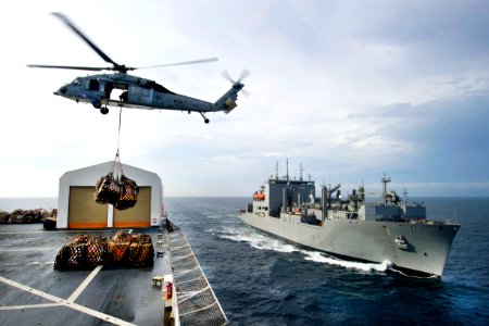 Defense.gov News Photo 110726-N-RM525-342 - An MH-60S Knight Hawk helicopter transports cargo from the USNS Comfort to the USNS Lewis and Clark during a replenishment mission underway in the photo