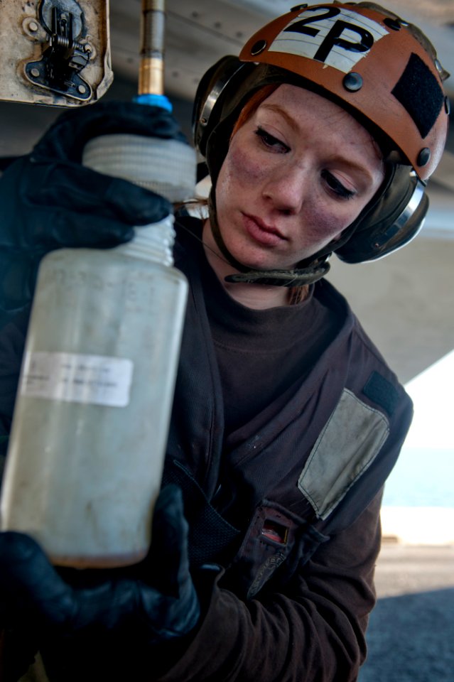 Defense.gov News Photo 120103-N-OY799-025 - Airman Samantha Phillips collects fuel samples from an F A-18E Super Hornet from Strike Fighter Squadron 14 on the flight deck of the aircraft