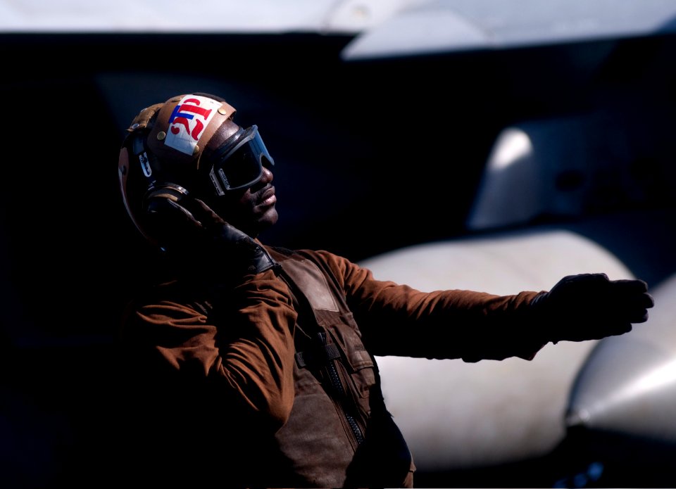 Defense.gov News Photo 120107-N-TZ605-397 - U.S. Navy Airman Michael Johnson a plane captain assigned to Strike Fighter Squadron 81 signals to an F A-18E Super Hornet aircraft pilot during