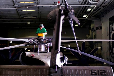 Defense.gov News Photo 120112-N-TZ605-429 - U.S. Navy Petty Officer 2nd Class Patrick Sablan performs maintenance on an SH-60F Seahawk helicopter in the hangar bay of the aircraft carrier USS