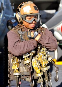 Defense.gov News Photo 120120-N-YB753-016 - A plane captain carries tie-down chains across the flight deck of the aircraft carrier USS Abraham Lincoln CVN 72 in the Arabian Sea on Jan. 20
