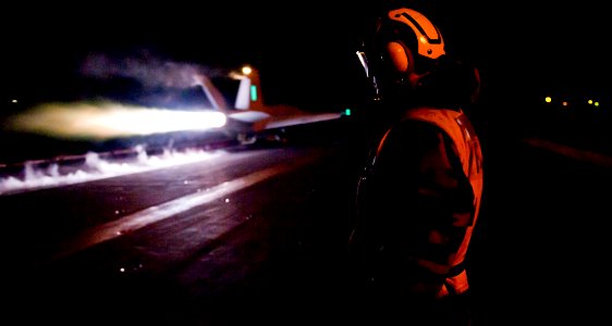 Defense.gov News Photo 111203-N-OY799-381 - A U.S. Navy sailor observes as an aircraft launches during night flight operations on the flight deck of the aircraft carrier USS John C. Stennis CVN