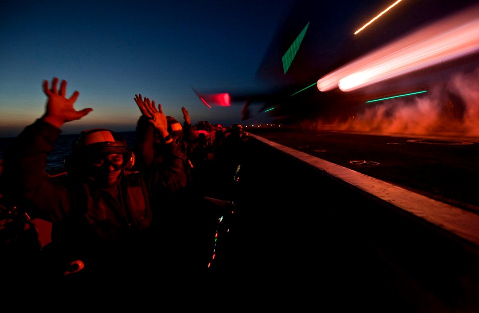 Defense.gov News Photo 120222-N-DR144-599 - U.S. Navy Petty Officer 2nd Class Blas Manzanares shows his hands are clear of the control panel as an F A-18C Hornet aircraft launches from the