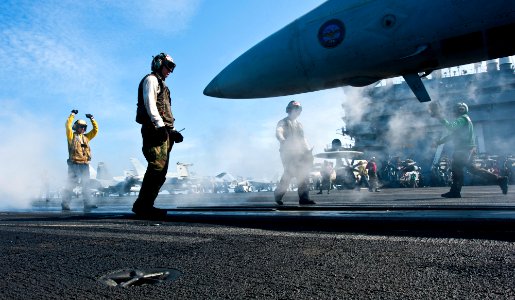 Defense.gov News Photo 120124-N-OY799-472 - U.S. Navy Airman Michael Linscott directs an F A-18E Super Hornet aircraft assigned to Strike Fighter Squadron 14 during flight operations on the