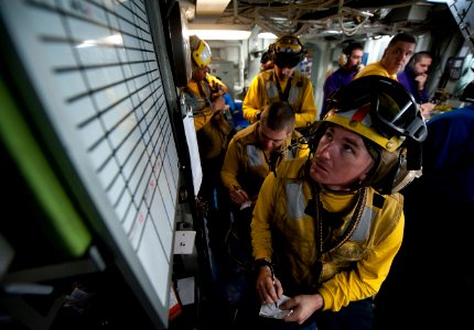 Defense.gov News Photo 120229-N-DR144-070 - Petty Officer 2nd Class Jathan Lane and other aircraft directors take notes about the next event between aircraft launch and recovery cycles in