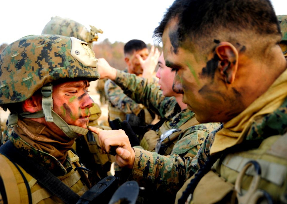 Defense.gov News Photo 120303-N-SD300-026 - Cpl. Mario Melendez right assigned to 2nd Platoon Company Pacific Fleet Anti-Terrorism Security Team applies camouflage paint to Lance Cpl