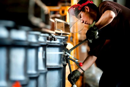 Defense.gov News Photo 120315-N-DR144-286 - U.S. Navy Seaman Erickson Schafer bands barrels of hazardous waste for offload to a Military Sealift Command ship aboard the aircraft carrier USS