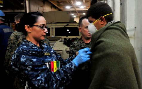 Defense.gov News Photo 120124-N-CT127-251 - A U.S. Navy sailor provides medical care to a rescued Moroccan mariner aboard the amphibious transport dock ship USS Mesa Verde LPD 19 in the