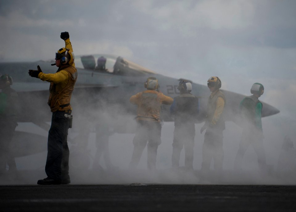 Defense.gov News Photo 120416-N-DR144-568 - An aircraft director guides an F A-18 Hornet onto the bow catapults for launch on the flight deck of the aircraft carrier USS Carl Vinson CVN 70