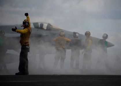 Defense.gov News Photo 120416-N-DR144-568 - An aircraft director guides an F A-18 Hornet onto the bow catapults for launch on the flight deck of the aircraft carrier USS Carl Vinson CVN 70