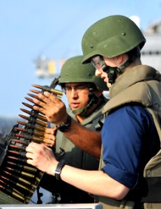 Defense.gov News Photo 120328-N-DB801-466 - U.S. Navy Petty Officer 1st Class Eduardo Soto left instructs Seaman Tyler Bishop on firing a .50 caliber machine gun during a live-fire exercise