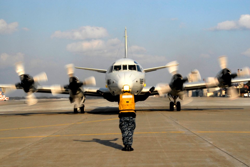 Defense.gov News Photo 120405-N-KR471-186 - U.S. Navy Airman Mark Jimenez with Patrol Squadron 1 signals the pilots of a P-3 Orion aircraft before takeoff in northern Japan on April 5