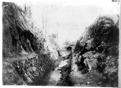 Ditch with water leading to tunnel, with one man LCCN2002717780