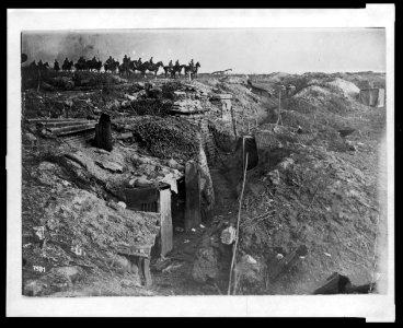 Abandoned British trench which was captured by the Germans; in background, German soldiers on horseback view the scene LCCN2005697195