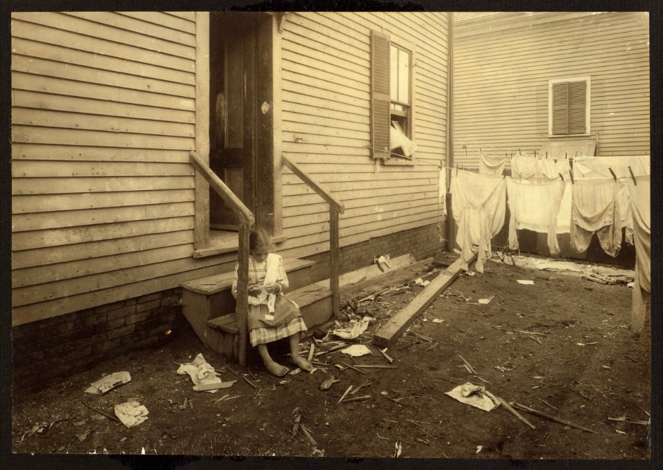 Annie Fedele crocheting on underwear out in the filthy back yard. This is one of the places she works on crochet. See other photos and Home Work report. LOC nclc.04223