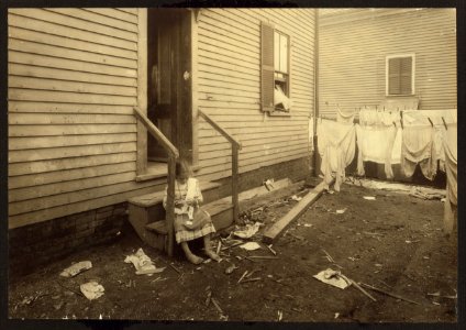 Annie Fedele crocheting on underwear out in the filthy back yard. This is one of the places she works on crochet. See other photos and Home Work report. LOC nclc.04223