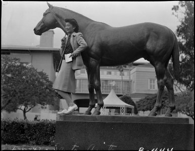 Arcadia, California. Mrs. Lily Okuru poses with statue of Seabiscuit in Santa Anita Park, now an . . . - NARA - 537056
