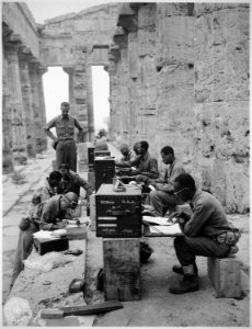 A company of men has set up its office between the columns (Doric) of an ancient Greek temple of Neptune, built about 7 - NARA - 531170 photo