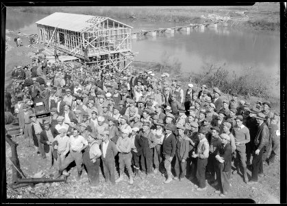 A group showing some of the men working at Norris Dam site. In the rear can be seen the warehouse under construction... - NARA - 532716 photo