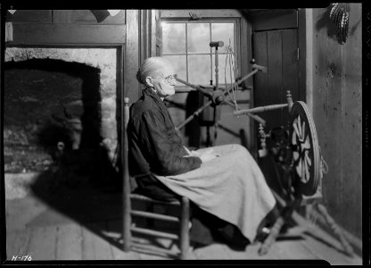 Another view of Mrs. Jacob Stooksbury, Loyston, Tennessee, seated before a spinning wheel in her home. The creel in... - NARA - 532793 photo