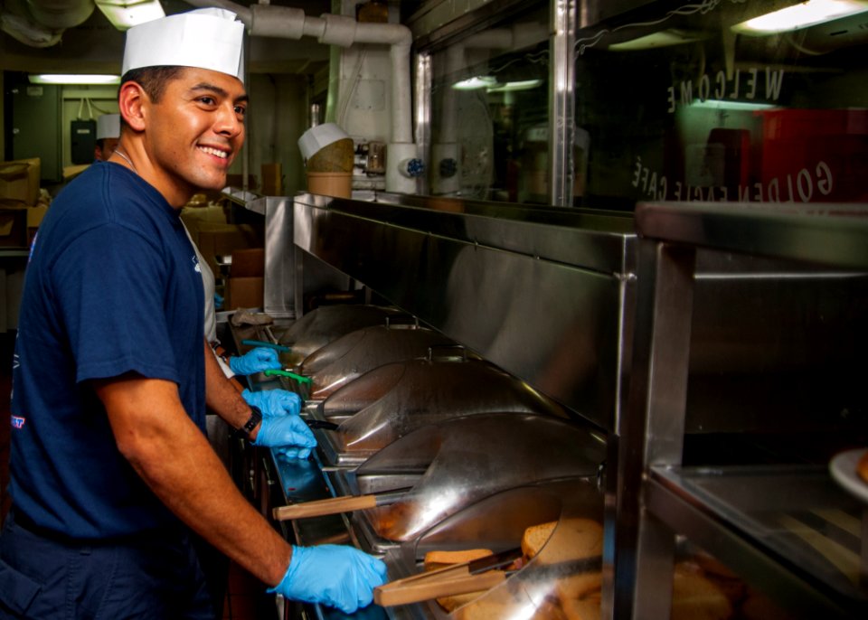 1st Class Petty Officer Association Sailors serve food aboard USS Carl Vinson 141028-N-WD464-134