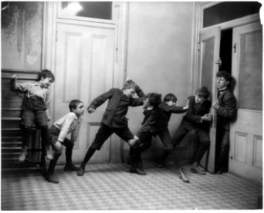 2 boys fighting and 2 boys pushing on door through which school teacher is trying to enter LCCN2003675196