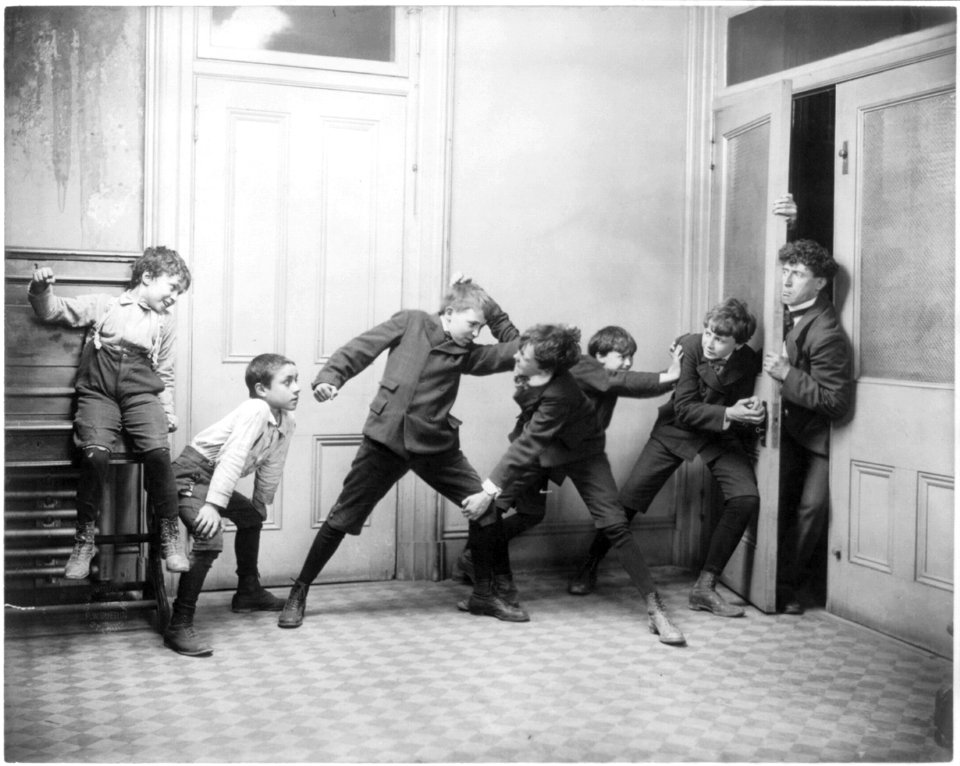 2 boys fighting in schoolroom while 2 others try to prevent teacher from entering room LCCN2003681240