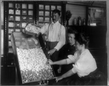 2 women and a man and a tray of silk cocoons LCCN2005684993