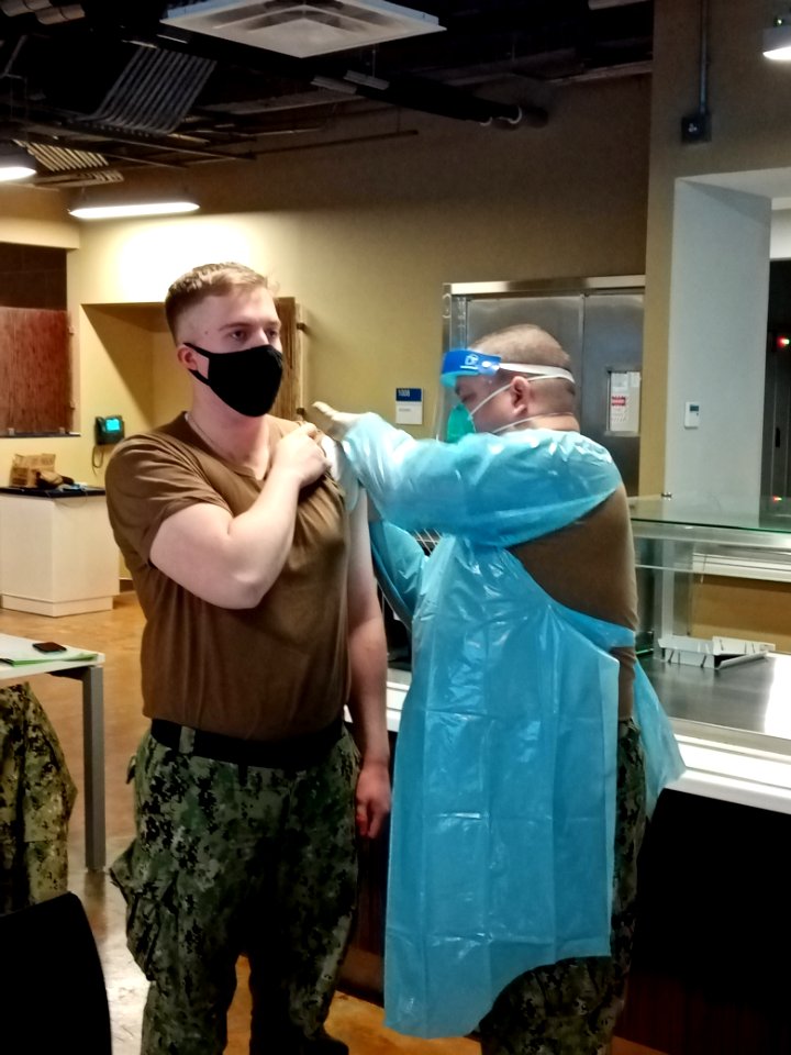 210216-N-ZZ999-002 Master-at-Arms 3rd Class Christopher Montgomery, a Sailor assigned to Naval Support Facility (NSF) Redzikowo, Poland, receives his first dose of the Moderna COVID-19 vaccine