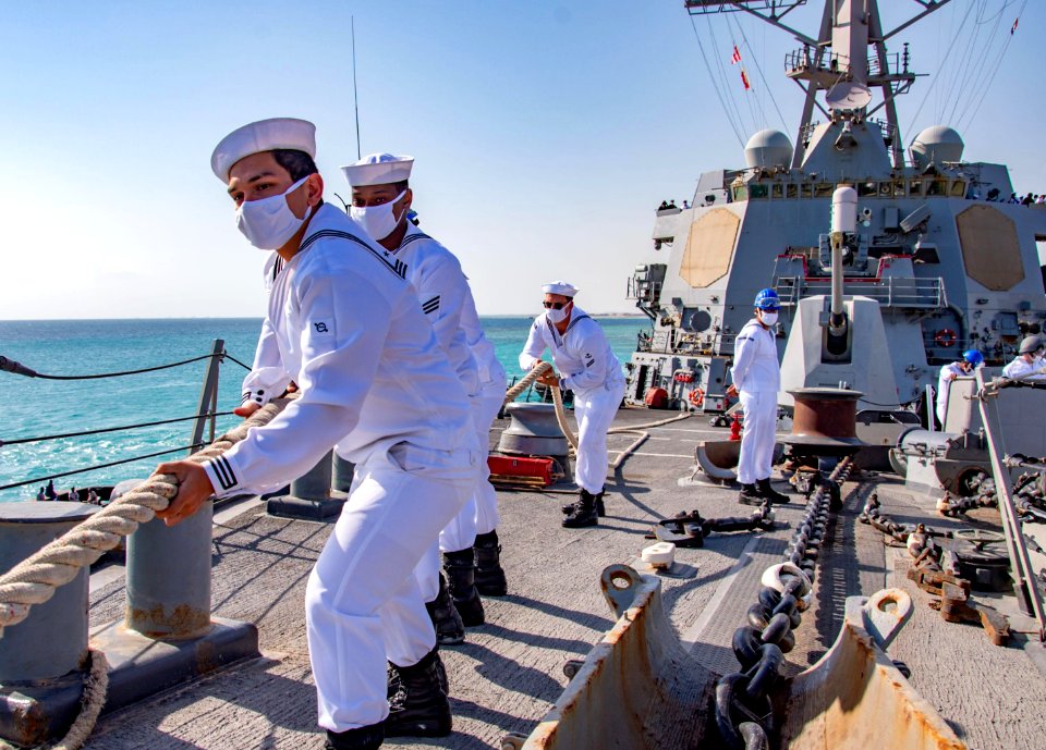 210301-N-PS962-1133 Line handlers aboard the guided-missile destroyer USS Winston S. Churchill (DDG 81) pull mooring lines tight