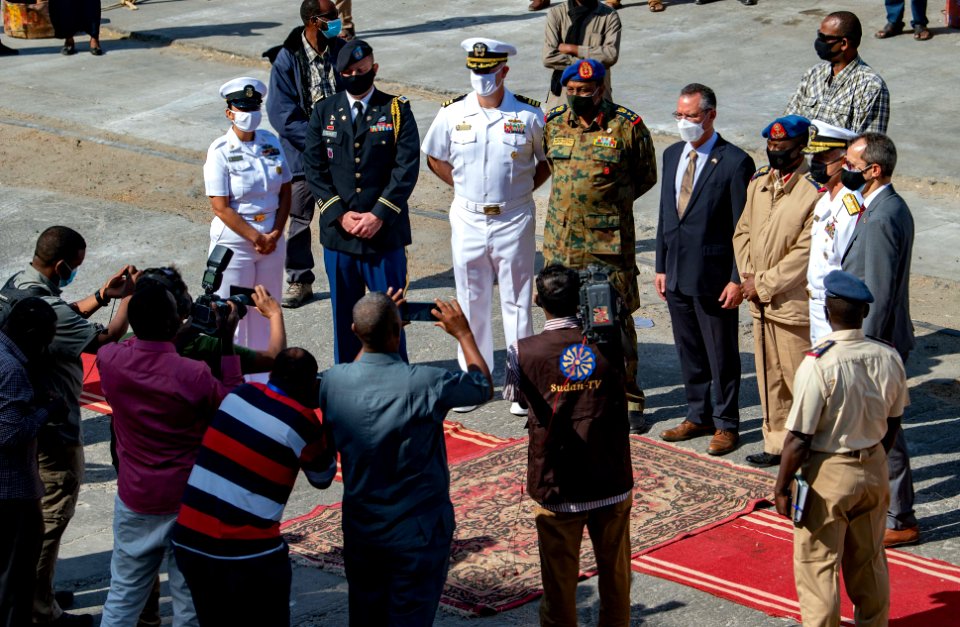 210301-N-PS962-1194 Cmdr. Timothy Shanley poses for photos with the official party during a scheduled port visit in Port Sudan, Sudan