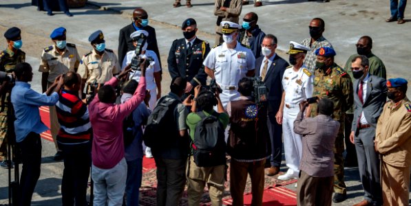 210301-N-PS962-1183 Cmdr. Timothy Shanley poses for photos with the official party during a scheduled port visit in Port Sudan, Sudan
