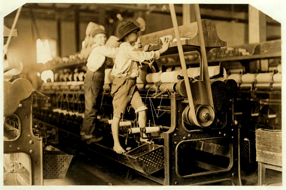 488 Macon, Ga. Lewis W. Hine 1-19-1909. Bibb Mill No. 1 Many youngsters here. Some boys were so small they had to climb up on the spinning frame to mend the broken threads and put back the LOC cph.3a01131