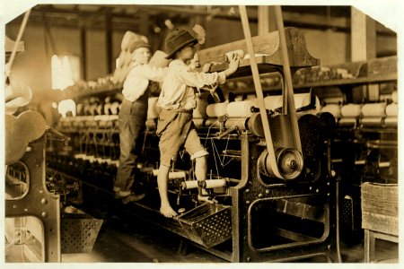 488 Macon, Ga. Lewis W. Hine 1-19-1909. Bibb Mill No. 1 Many youngsters here. Some boys were so small they had to climb up on the spinning frame to mend the broken threads and put back the LOC cph.3a01131