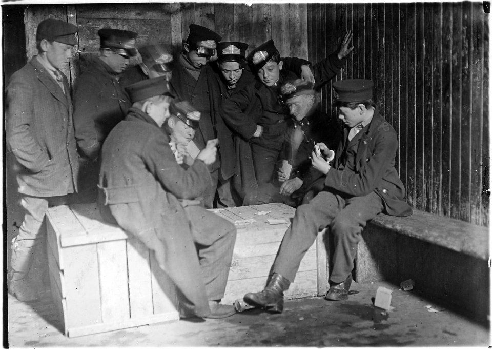 8 P.M. Flashlight photo of messengers absorbed in their usual game of poker in the Den of the terrible nine.... - NARA - 523167