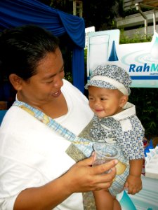 A baby happily drinking safe water while his mother looks at him lovingly. (17376816931)