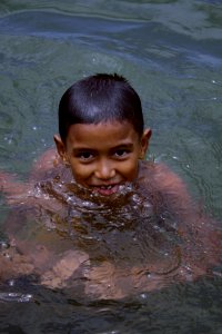 A boy swims at a river near a USAID funded community development project in Teumareum. (5074344626)