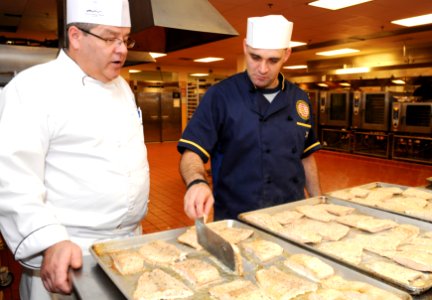 A chef teaches a Sailor to cook fish. (8284404414)