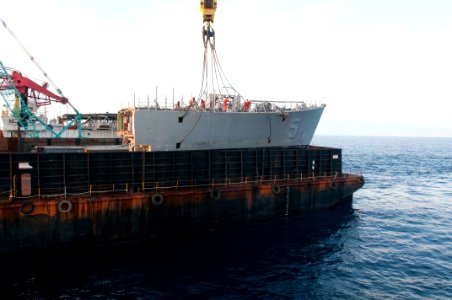 A crane vessel removes the bow of the former USS Guardian. (8594721207)