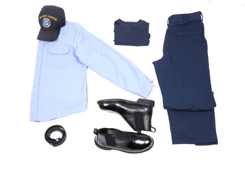 A display of the light blue over dark blue two-piece flame-resistant organizational clothing variant prototype intended for E6 and below sailors along with the molder boot, rigger’s belt, dark blue undershirt and ball cap