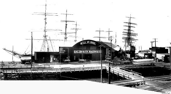 Asahel Curtis panoramic view of Galbraith, Bacon & Co Wall Street Dock and warehouse, Seattle, with sailing ships in background photo