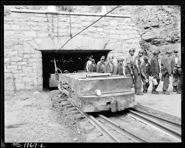 At this mine the motor hauling the man trip is stopped just after it emerges from mine portal. The men then get out... - NARA - 540923