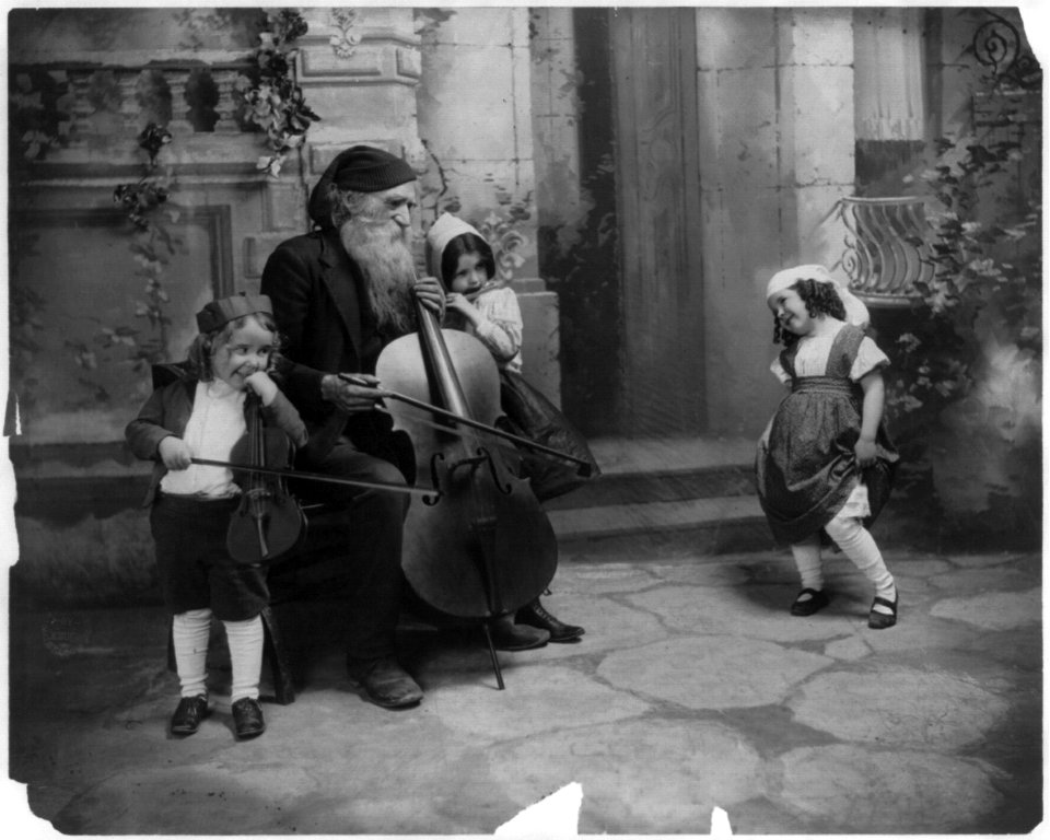 Bearded man and 2 children with cello & violin and small girl dancing LCCN2003677201
