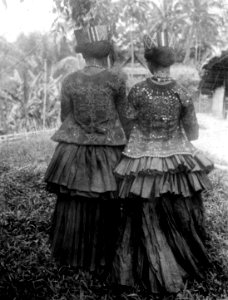 Behoakvinnor i högtidskläder på besök i Koelawi. Foto bakifrån. Kulawi, Sulawesi. Indonesien - SMVK - 000170