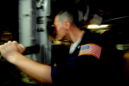 US Navy 070318-N-3642E-031 USS Alexandria (SSN 757) Commanding Officer, Cmdr. Michael Bernacchi looks through the periscope for a safe position to surface the boat photo